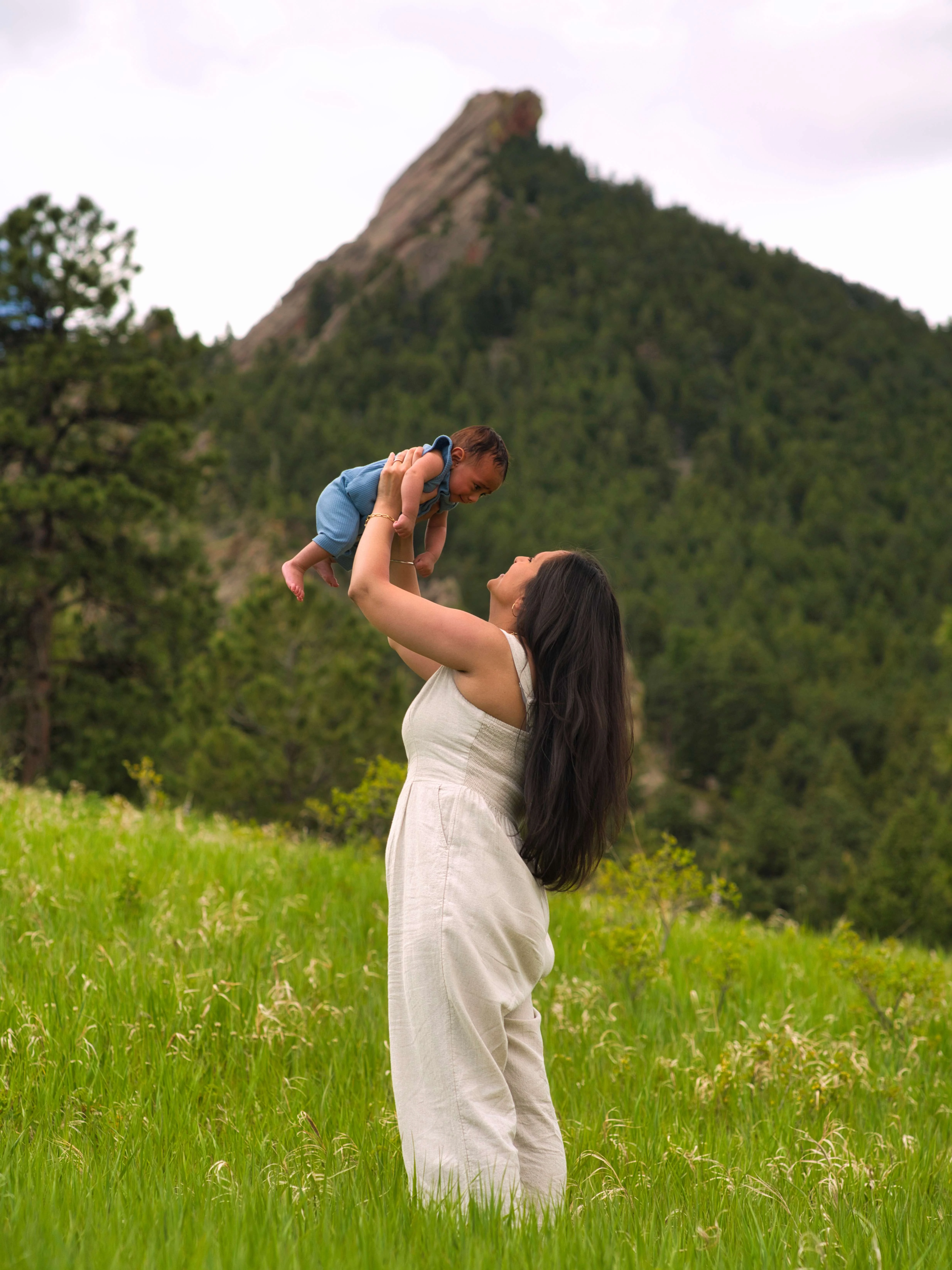 Mother and Baby Portrait – Boulder Colorado Field Mother lifting baby joyfully in mountain meadow, Boulder Colorado family photoshoot